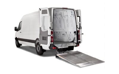 The back of a van with the doors open and a ramp leading into the back