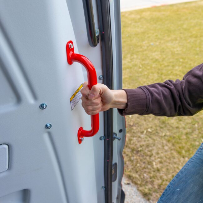 Closeup of worker using van grab handle to assist climbing into van.