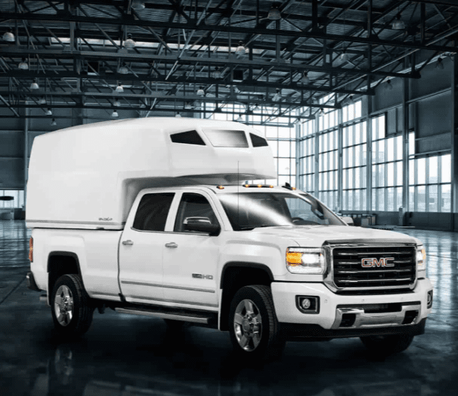 View of a SpaceKap Diablo installed on a GMC truck located in a open warehaouse.