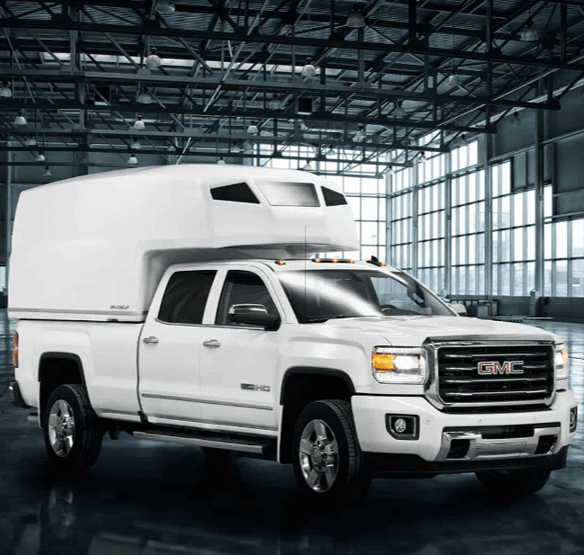 View of a SpaceKap Diablo installed on a GMC truck located in a open warehaouse.